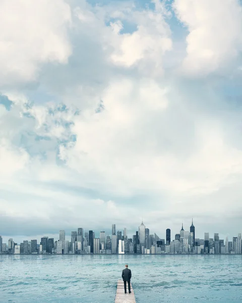 Empresario mirando la ciudad en un muelle — Foto de Stock