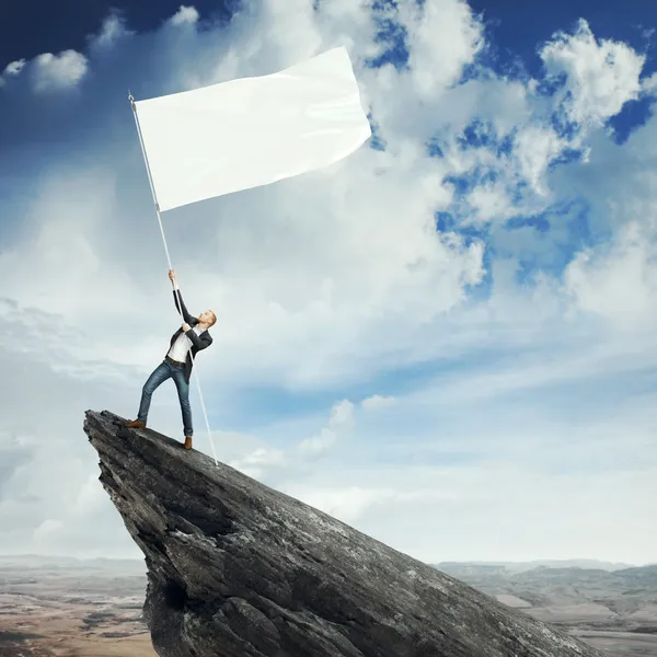 Hombre con bandera en un pico — Foto de Stock