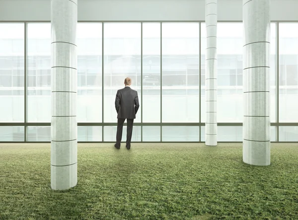 Businessman standing in bright green office — Stock Photo, Image