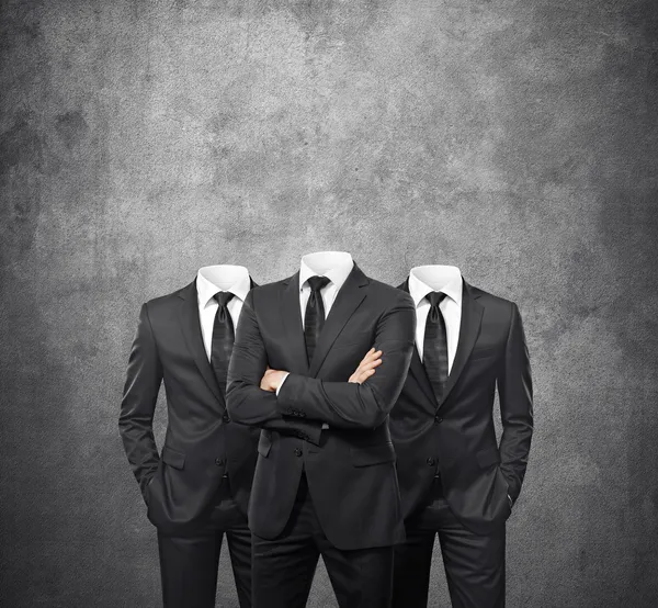 Group of businessmen without heads on concrete background — Stock Photo, Image