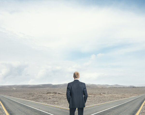 Businessman in front of two roads