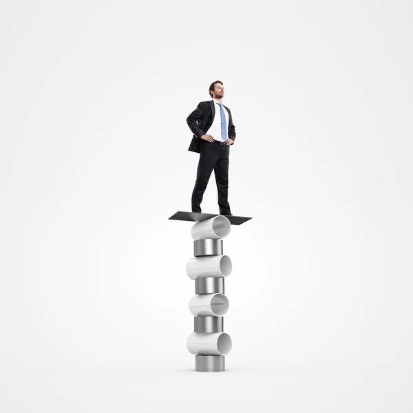 Businessman balancing on metal cylinders — Stock Photo, Image