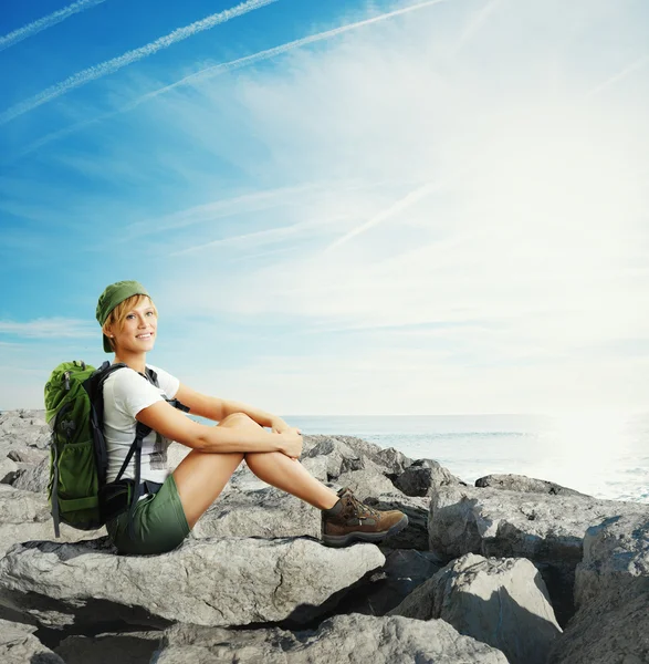 Traveler woman sitting on a rocks — Stock Photo, Image