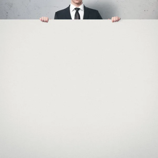 Empresário segurando cartaz em branco — Fotografia de Stock