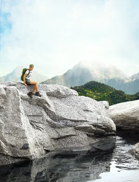 Young traveler woman sitting on a rock — Stock Photo, Image