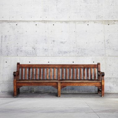Wooden bench against a wall building