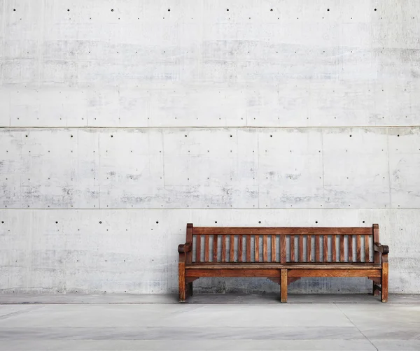 Деревянная скамейка напротив стены здания — стоковое фото