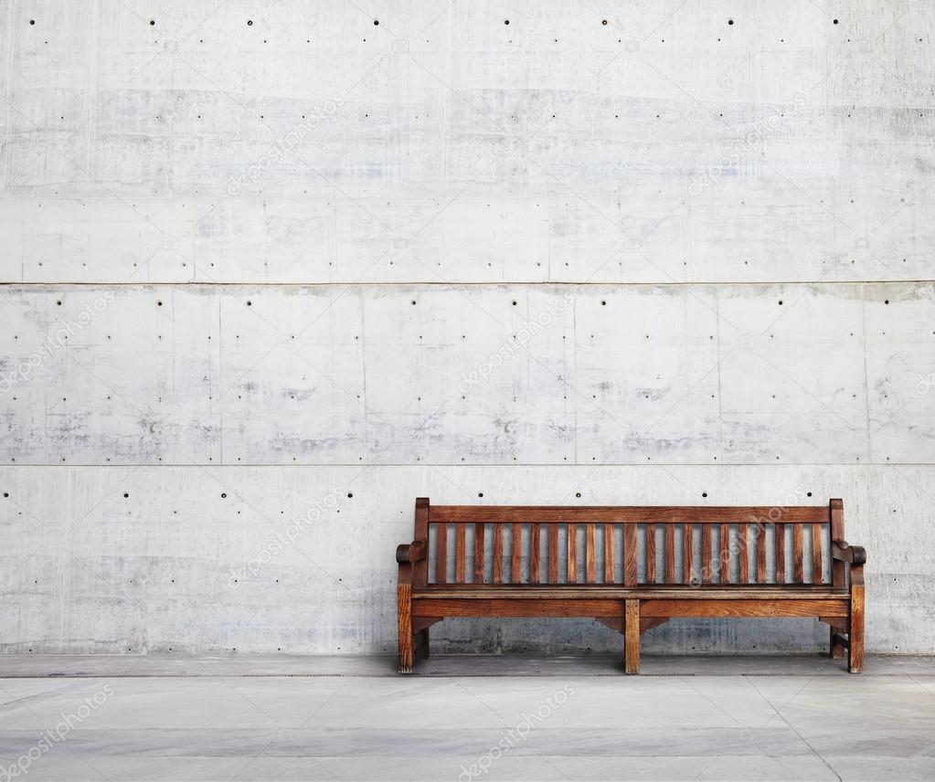 Wooden bench against a wall building