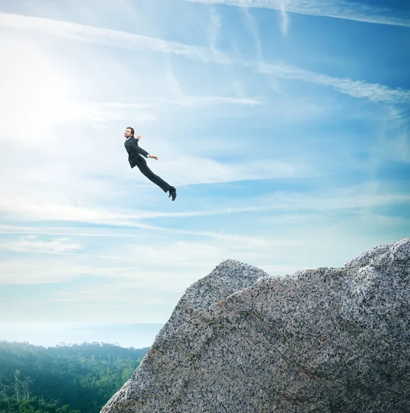 Man in suit flying over mountains — Stock Photo, Image