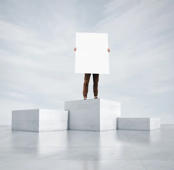 Man står på kuben och hålla tomt affisch — Φωτογραφία Αρχείου