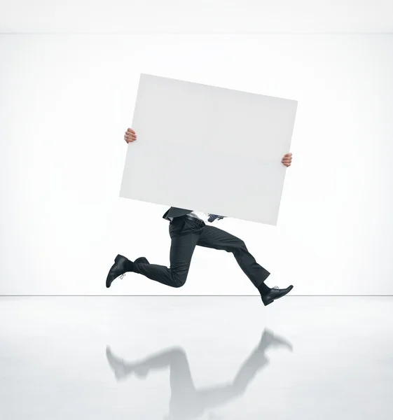 Running business man holding poster — Stock Photo, Image