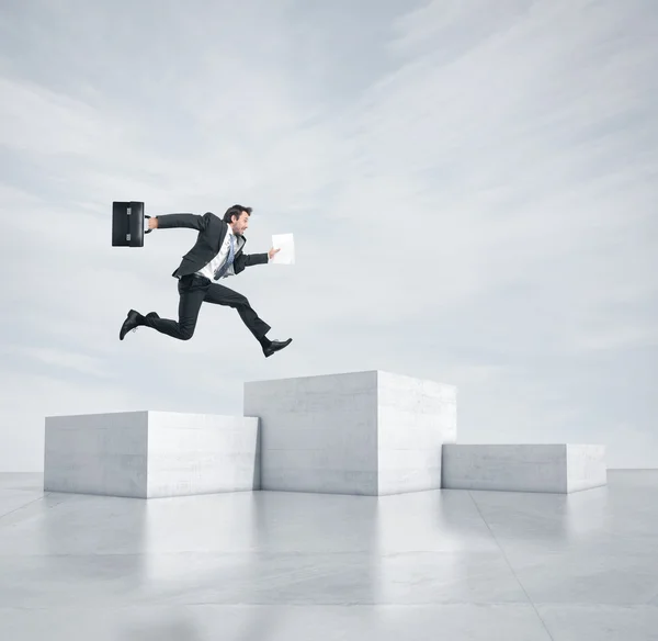 Empresário saltando para o cubo mais alto — Fotografia de Stock