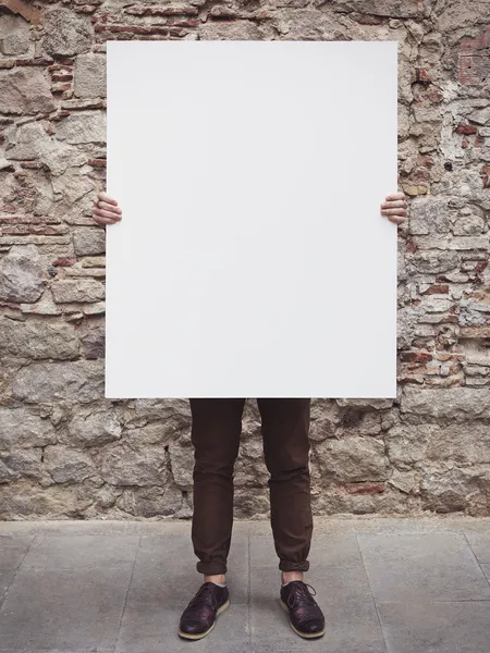Jovem segurando cartaz em branco — Fotografia de Stock
