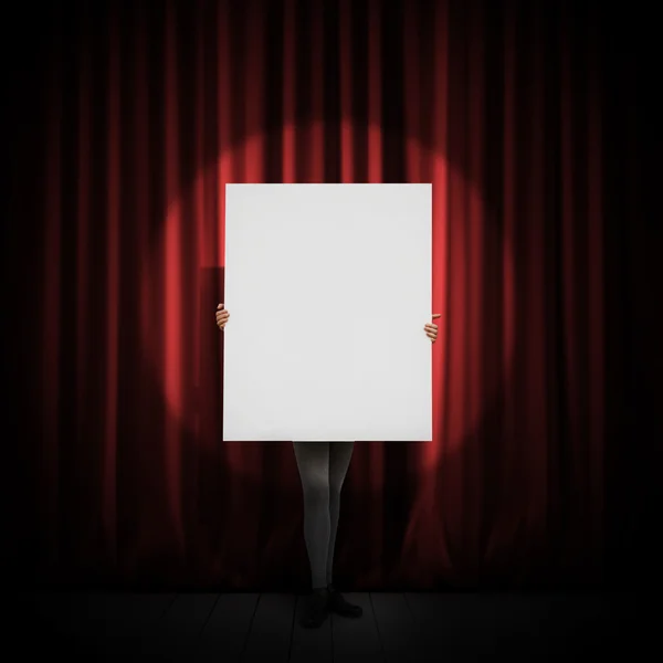 Mädchen steht mit leerem Plakat auf einer Bühne — Stockfoto