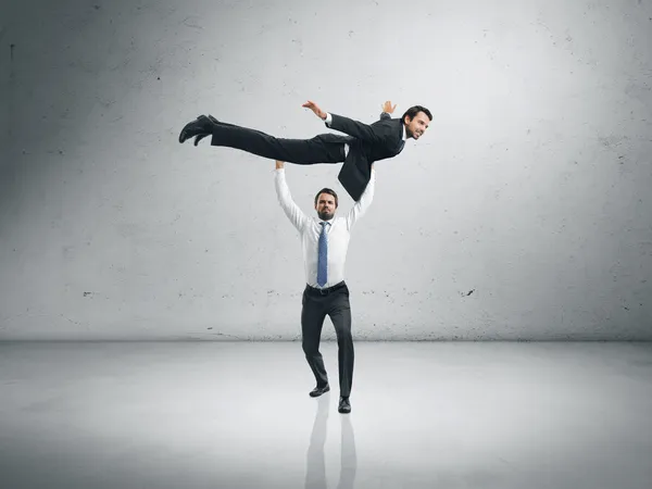 One businessman lifting the second one — Stock Photo, Image