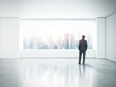 Boş ofis ayakta ve pencereden bakarak işadamı