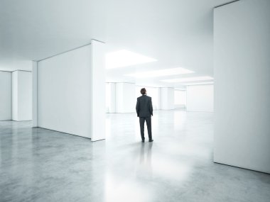 Boş beyaz ofiste ayakta işadamı