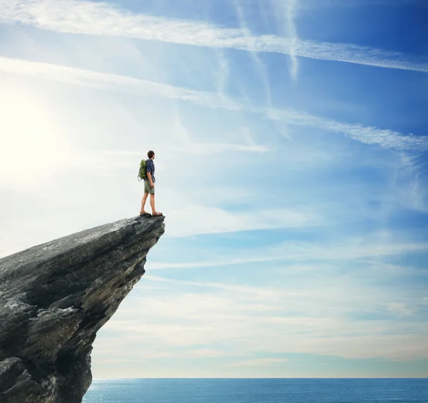 Young man standing on a peak — Stock Photo, Image