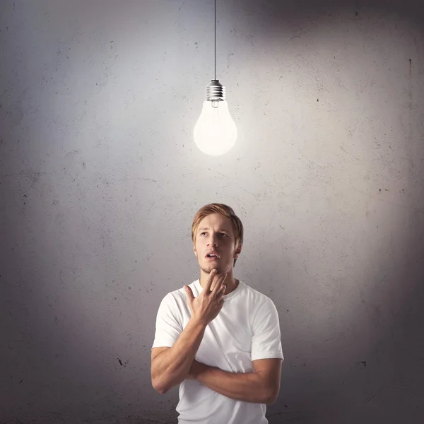 Portrait sur la pensée jeune homme regardant l'ampoule — Photo