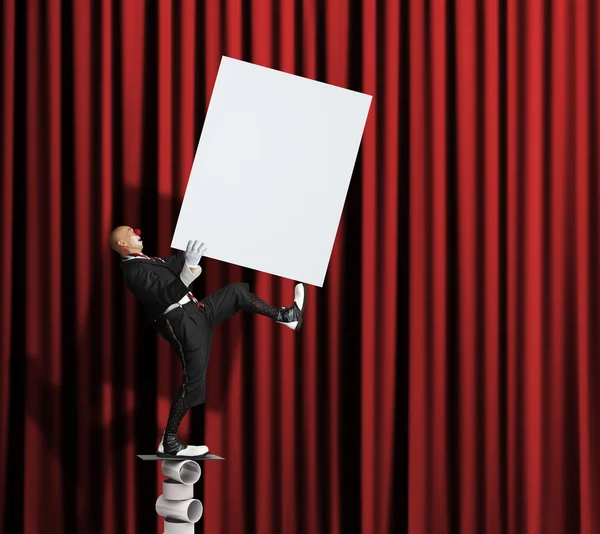 Balanceamento palhaço com cartaz em branco em suas mãos — Fotografia de Stock