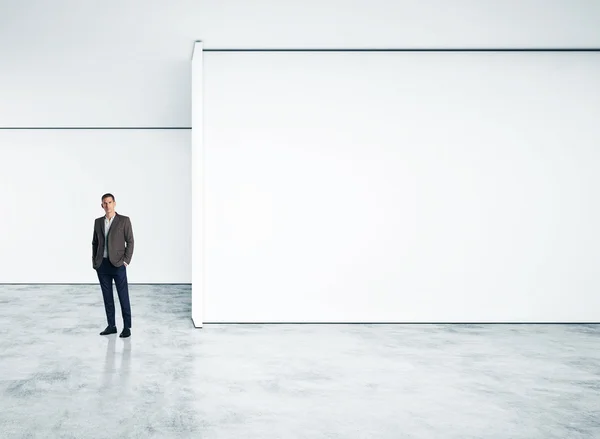 Επιχειρηματίας που στέκεται στο κενό φωτεινά γραφείο — Φωτογραφία Αρχείου
