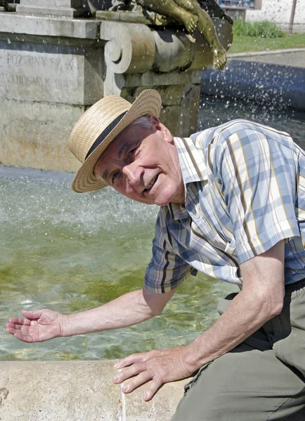 Senior junto a la fuente —  Fotos de Stock