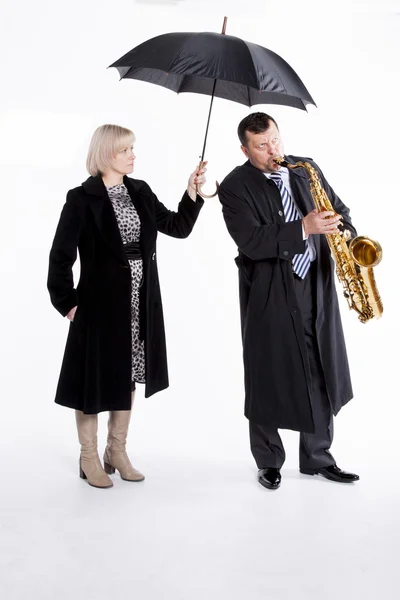 Saxophonist under an umbrella — Stock Photo, Image