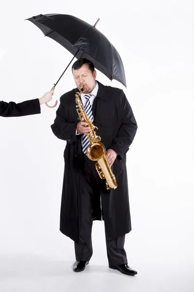 Saxophonist under an umbrella — Stock Photo, Image