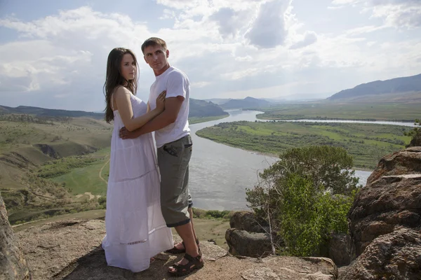 Pareja joven abrazándose en las montañas — Foto de Stock