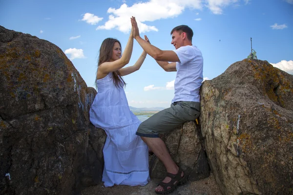 Pareja sentada en las rocas — Foto de Stock