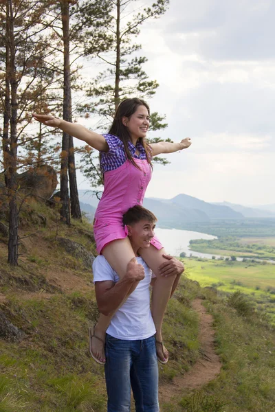 Jovem segurando a menina em um pescoço — Fotografia de Stock