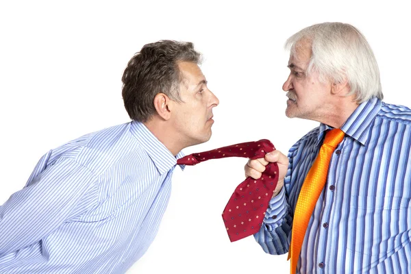 Empresario tirando de una corbata a un hombre más joven — Foto de Stock