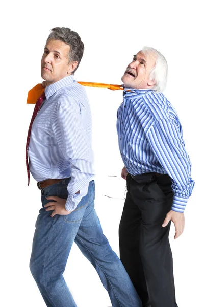 Biznesmen ciągnięcie krawat do starszego mężczyzny — Zdjęcie stockowe