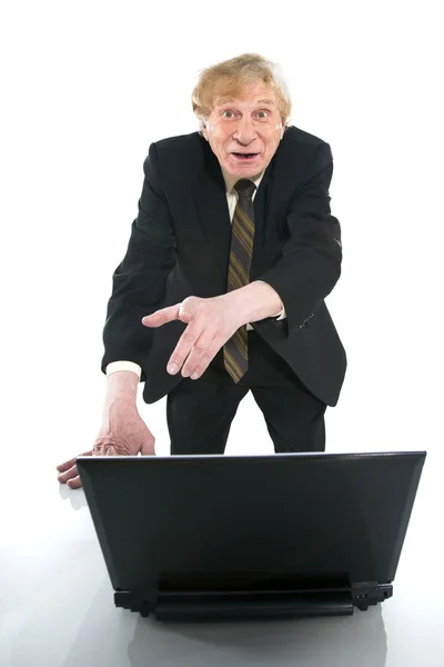 Businessman amazedly shows on laptop — Stock Photo, Image