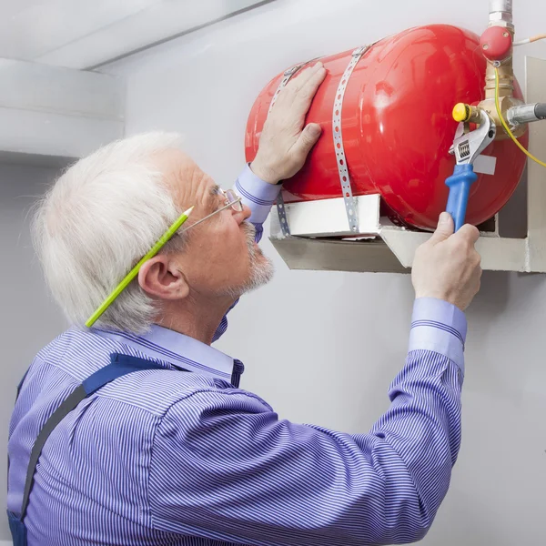 Człowiek instaluje gaśnica — Zdjęcie stockowe