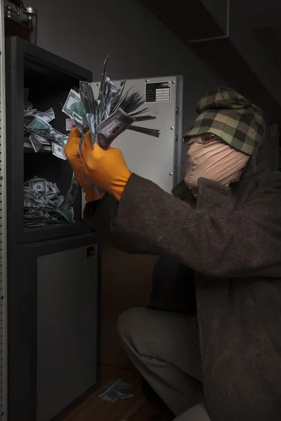 Un ladrón roba dinero de la caja fuerte — Foto de Stock