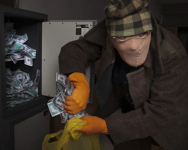 A thief steals money from the safe — Stock Photo, Image