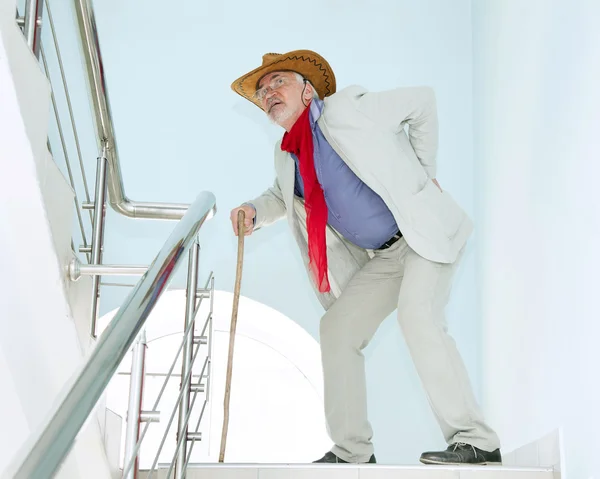 Человек поднимается по лестнице с болью в спине — стоковое фото