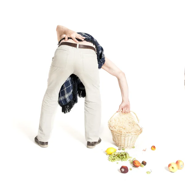 Homme avec mal de dos panier de fruits tombés — Photo