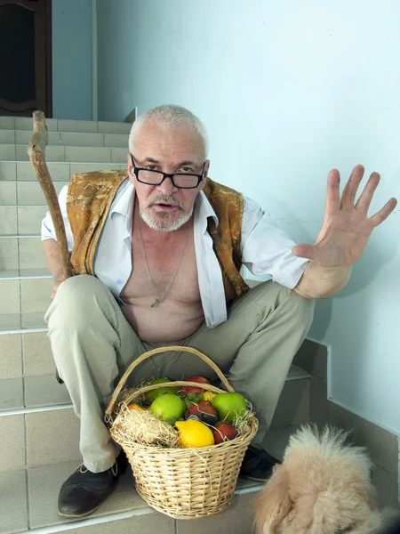 Emotionele man met een hond en een fruitmand — Stockfoto