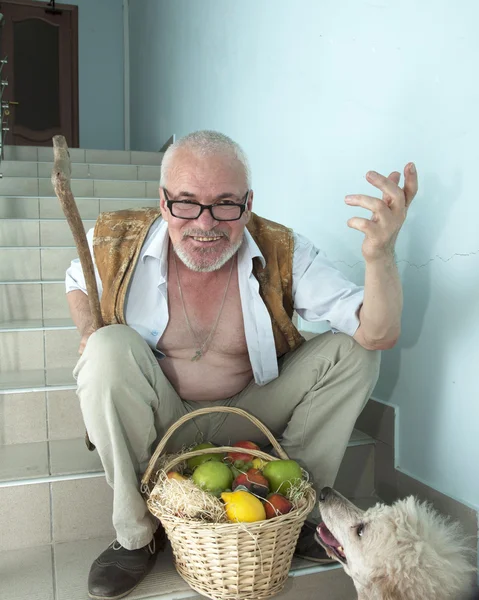 Uomo emotivo con un cane e un cesto di frutta — Foto Stock