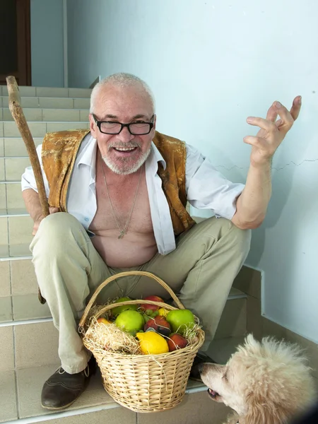 Uomo emotivo con un cane e un cesto di frutta — Foto Stock