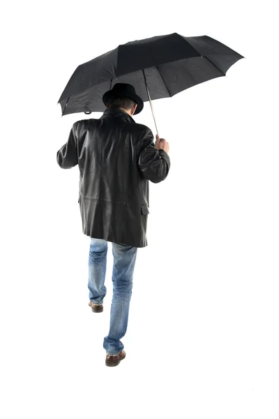 Man met zwarte paraplu lopen op een witte achtergrond — Stockfoto