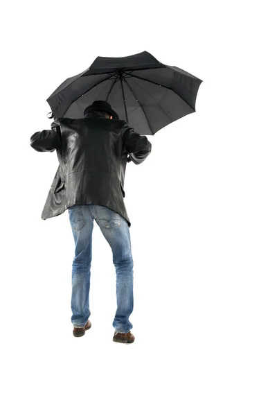 Man met zwarte paraplu lopen op een witte achtergrond — Stockfoto