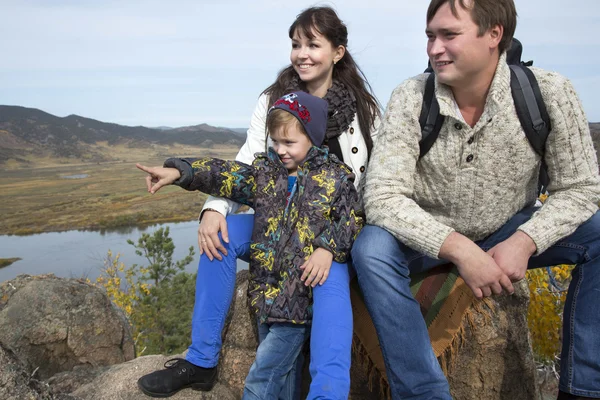 Family sitting on the stone and looking towards — Stock Photo, Image