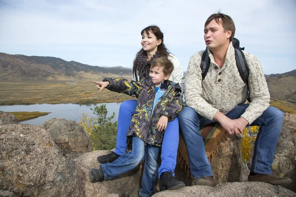 Familia sentada en la piedra y mirando hacia — Foto de Stock