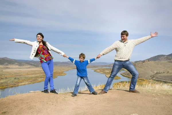 Happy family jumping on the mountain — Stock Photo, Image