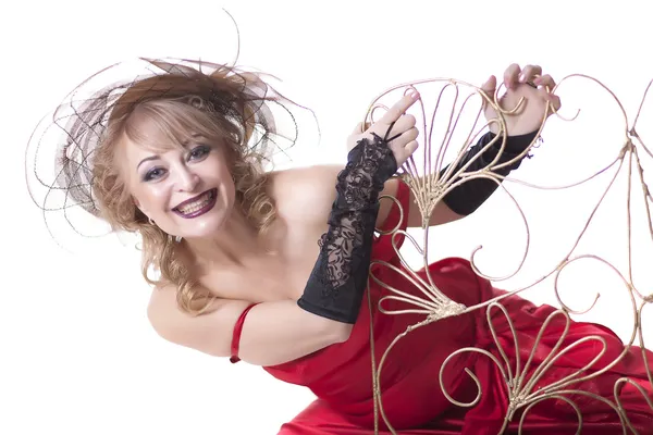 A woman in a red dress posing on a chair — Stock Photo, Image