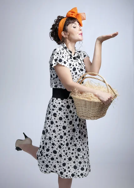 Jovencita sosteniendo una cesta y enviando un beso aéreo —  Fotos de Stock