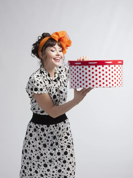 Happy girl opening gift box with red polka dots — Stock Photo, Image